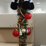 A coat rack decorated with Christmas tree ornaments