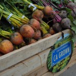 A crate full of root vegetables, marked Buy California Grown