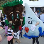 Child talks to costumed mascots at Ag Day