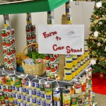 A fruit stand built out of canned goods, decorated with Christmas lights