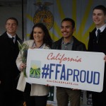 FFA students holding an over-sized license plate reading #FFAProud