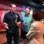 Luis Delgadillo walks through an exhibit with Rick Pickering and Karen Ross
