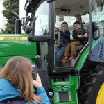 Two children sitting in a large tractor on Ag Day
